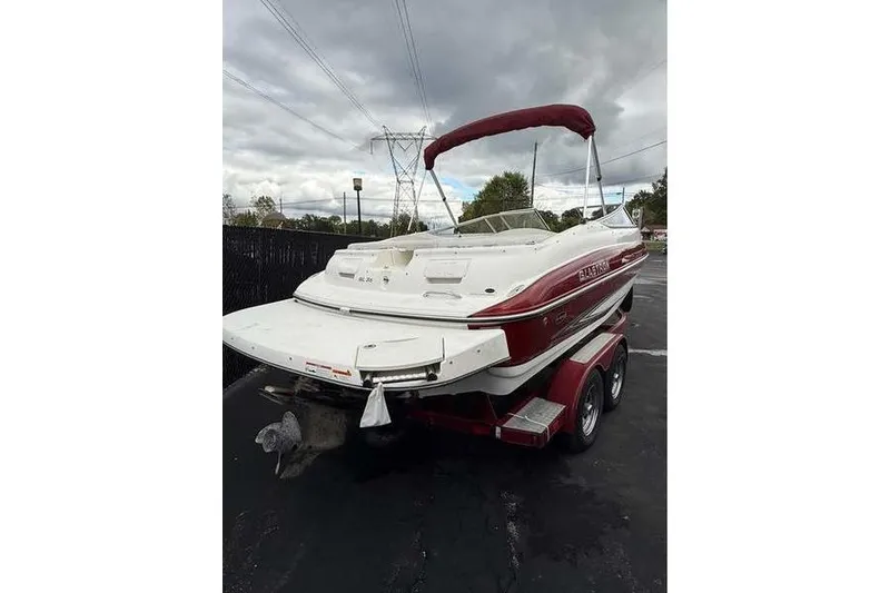 Slide: The Image of 2007 Glastron GXL 205 boat on trailer, red and white design, overcast sky. - 2