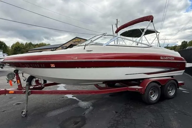 Slide: The Image of 2007 Glastron GXL 205 boat on trailer, red and white design, parked outdoors. - 9