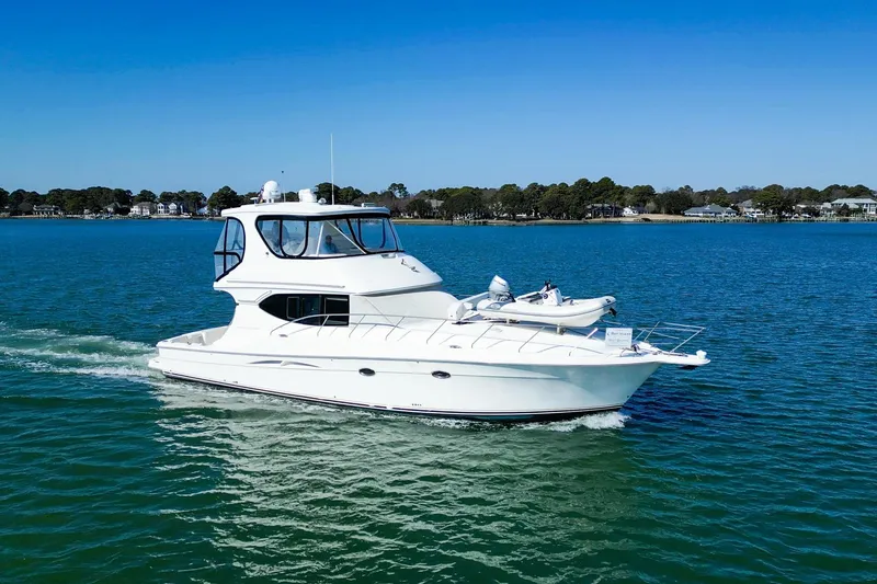 The Image of 2004 Silverton 48 Convertible yacht cruising on a clear blue lake. - 0