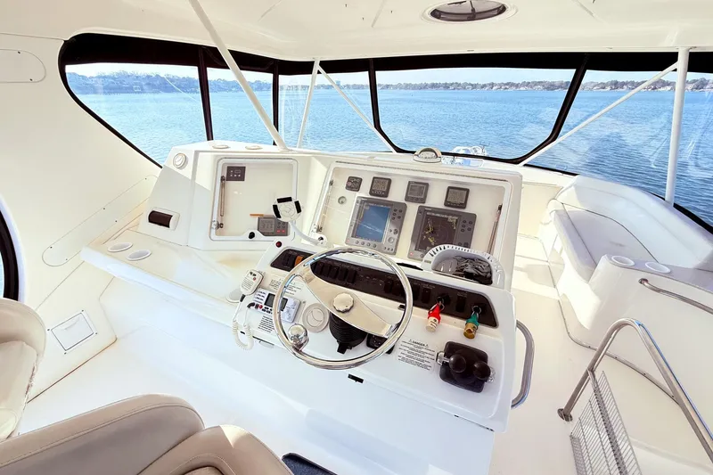 Slide: The Image of 2004 Silverton 48 Convertible yacht helm with navigation instruments and panoramic water view. - 10