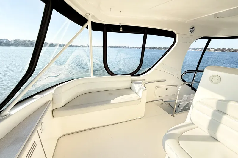 Slide: The Image of Interior view of a 2004 Silverton 48 Convertible yacht with spacious seating and panoramic windows. - 18