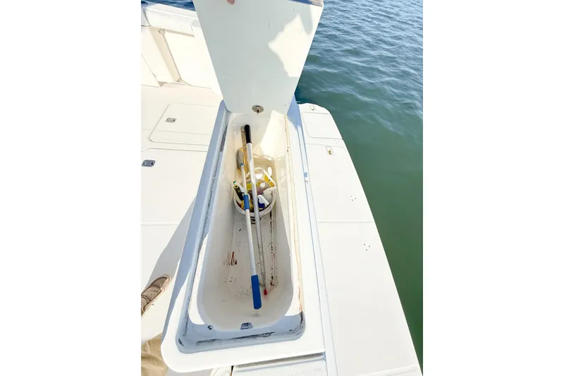 Slide: The Image of Open storage compartment on 2004 Silverton 48 Convertible boat, containing cleaning supplies. - 25