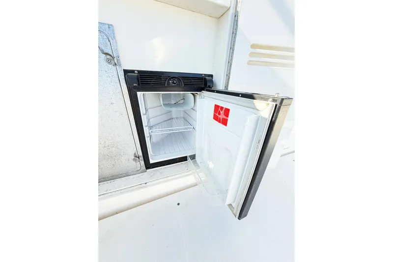 Slide: The Image of Open refrigerator on 2004 Silverton 48 Convertible yacht, showcasing interior storage space. - 28