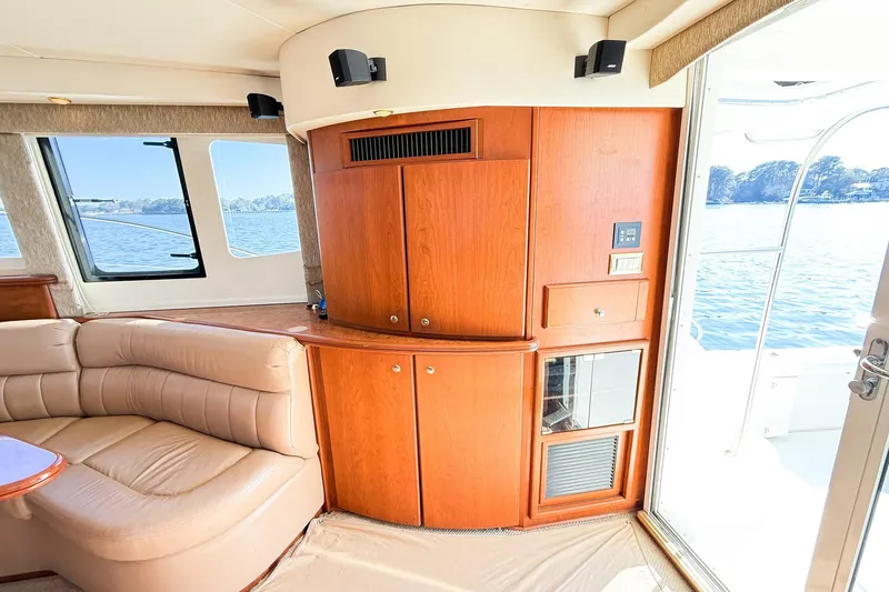 Slide: The Image of Interior of 2004 Silverton 48 Convertible yacht with wood cabinetry and leather seating by a window. - 37