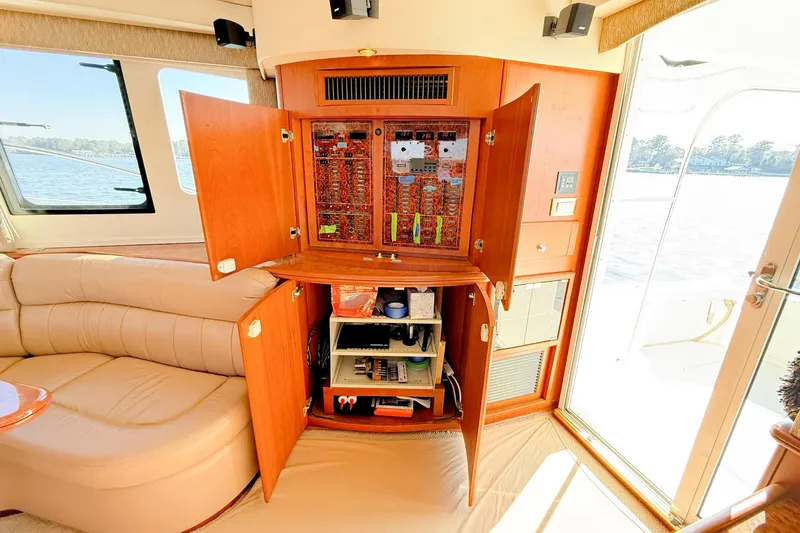 Slide: The Image of 2004 Silverton 48 Convertible yacht interior with open electrical panel and beige seating. - 38