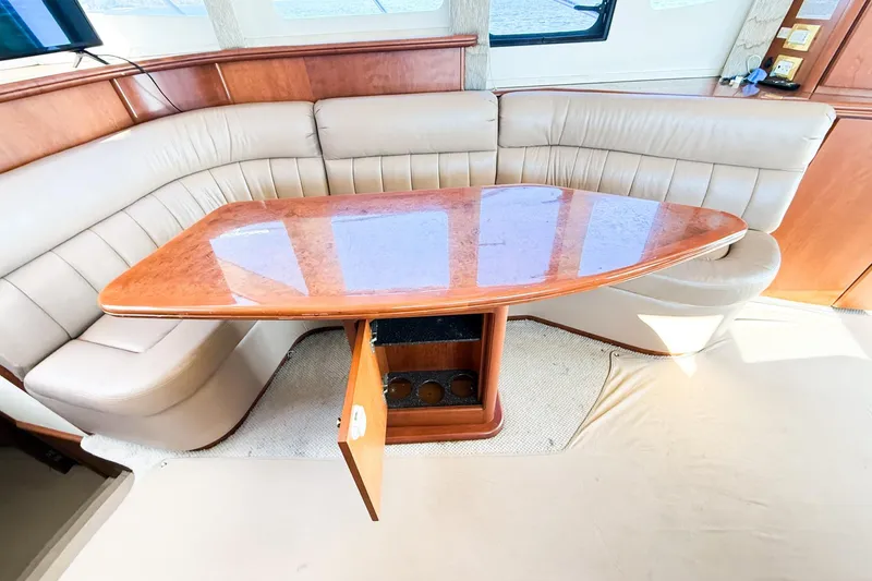 Slide: The Image of Luxurious interior of 2004 Silverton 48 Convertible yacht with elegant seating and wooden table. - 39
