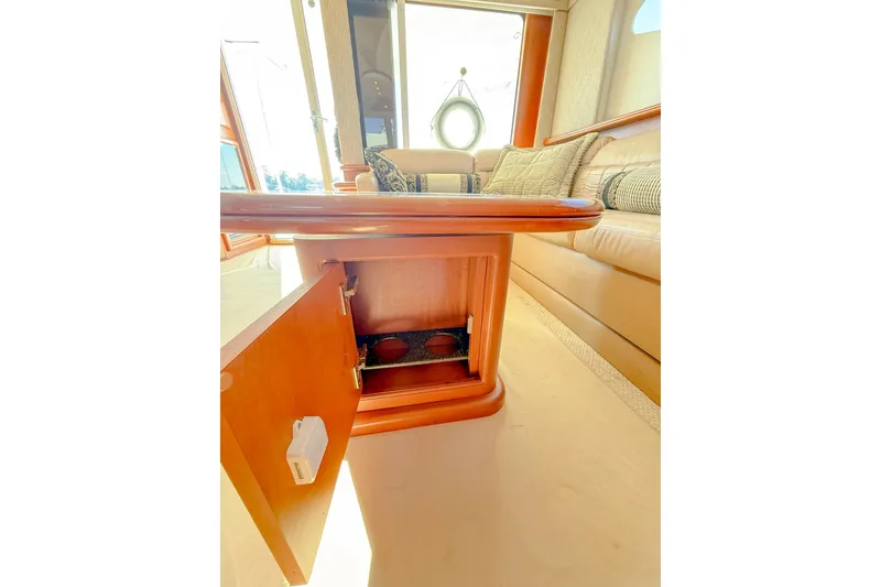 Slide: The Image of 2004 Silverton 48 Convertible yacht interior with open wooden cabinet and plush seating. - 40