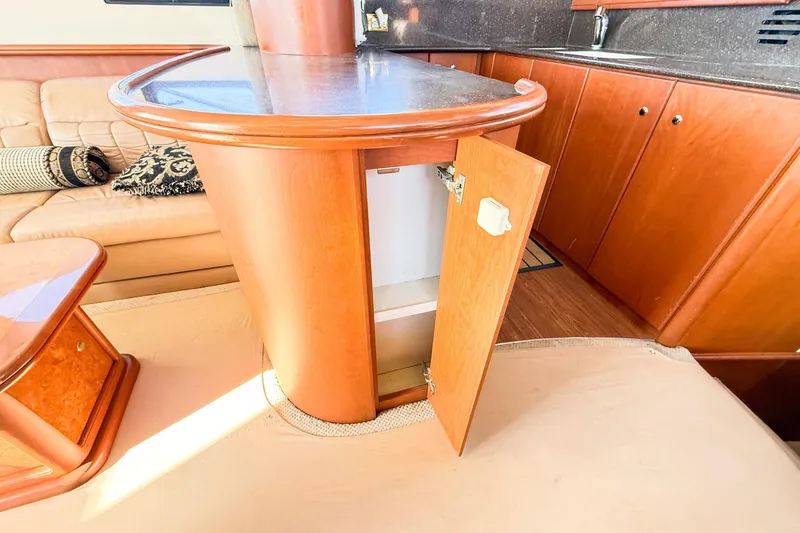 Slide: The Image of 2004 Silverton 48 Convertible yacht interior with open cabinet and luxurious seating. - 42