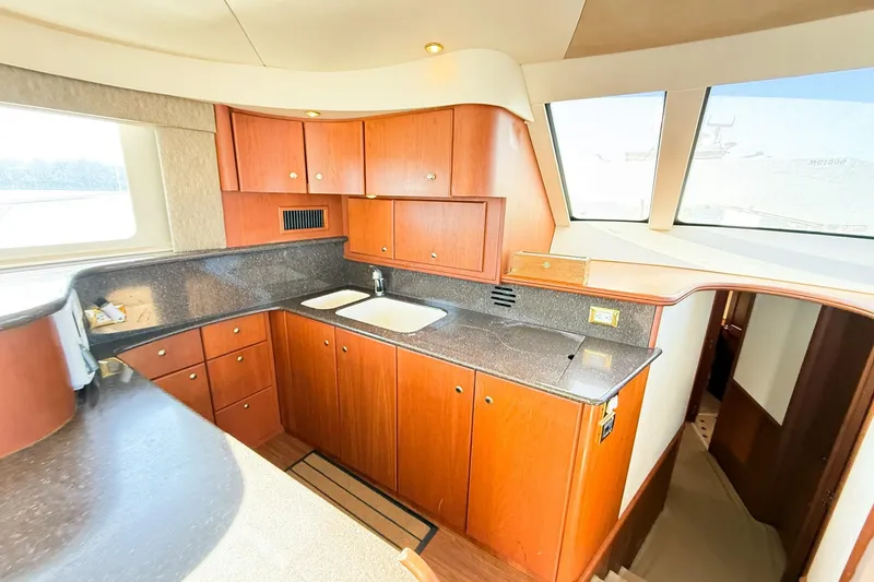 Slide: The Image of Luxurious 2004 Silverton 48 Convertible yacht kitchen with wood cabinetry and modern countertops. - 43