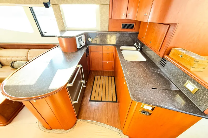 Slide: The Image of Luxurious kitchen interior of 2004 Silverton 48 Convertible yacht with wood cabinetry. - 44