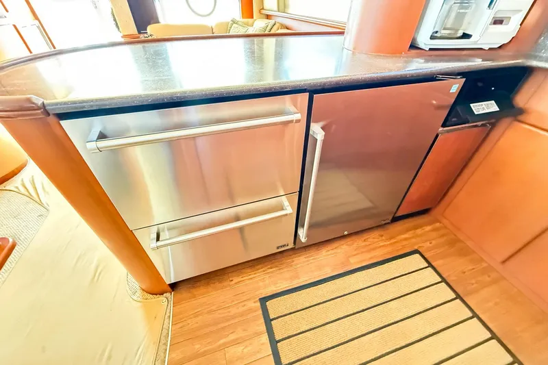 Slide: The Image of 2004 Silverton 48 Convertible yacht kitchen with stainless steel appliances and wood flooring. - 45