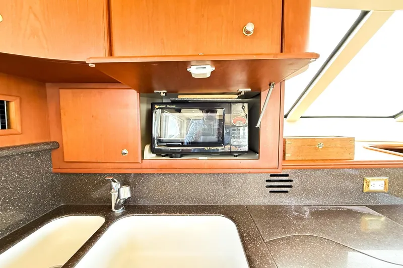 Slide: The Image of Kitchen area of 2004 Silverton 48 Convertible yacht with microwave and sink. - 51