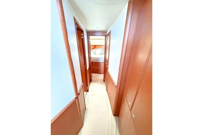 Slide: The Image of Hallway inside 2004 Silverton 48 Convertible yacht, featuring wooden paneling and a view into a cabin. - 53