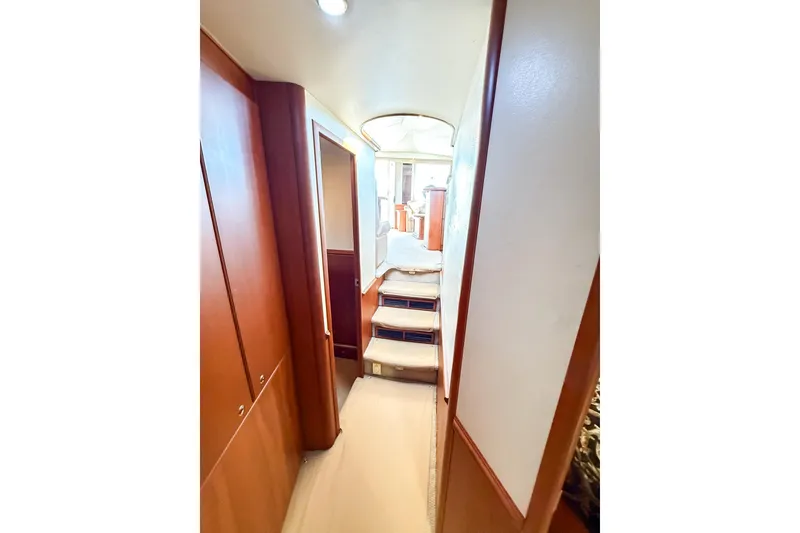 Slide: The Image of Interior hallway of 2004 Silverton 48 Convertible yacht with wooden cabinetry and carpeted steps. - 54