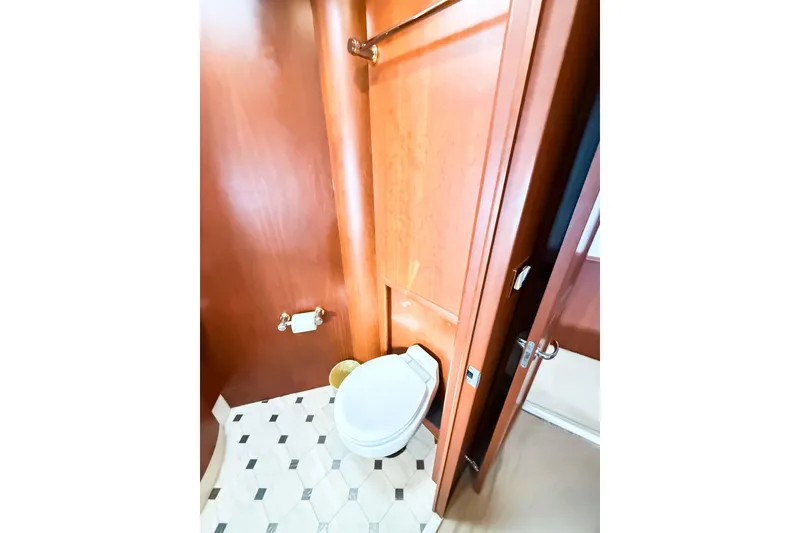 Slide: The Image of Bathroom interior of 2004 Silverton 48 Convertible yacht with wooden paneling and tiled floor. - 58