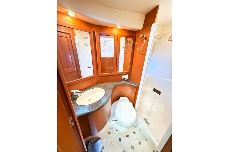 Slide: The Image of Luxurious bathroom in 2004 Silverton 48 Convertible yacht with modern fixtures and wood accents. - 63