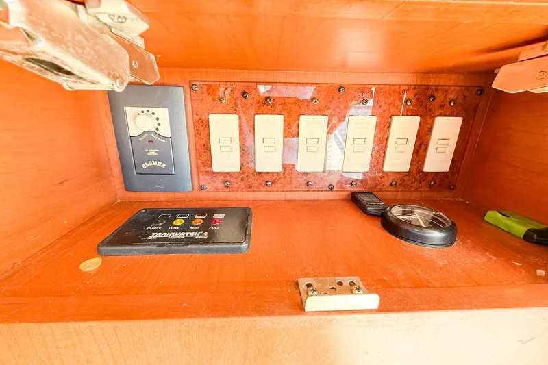 Slide: The Image of Control panel inside 2004 Silverton 48 Convertible yacht, featuring switches and electronic devices. - 66