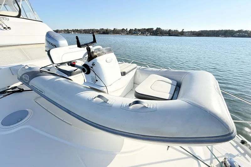 Slide: The Image of 2004 Silverton 48 Convertible yacht with inflatable tender on deck, scenic water view. - 72