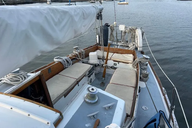Slide: The Image of 1969 Tartan 37 sailboat deck with ropes and seating, moored on calm water. - 1