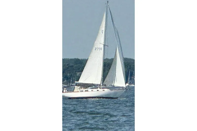 Slide: The Image of Sailboat on water, Tartan 37 model from 1969, with white sails and scenic background. - 12