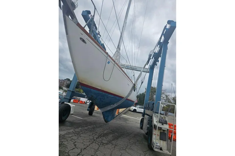 Slide: The Image of Tartan 37 sailboat from 1969 being lifted by a travel lift at a marina. - 14