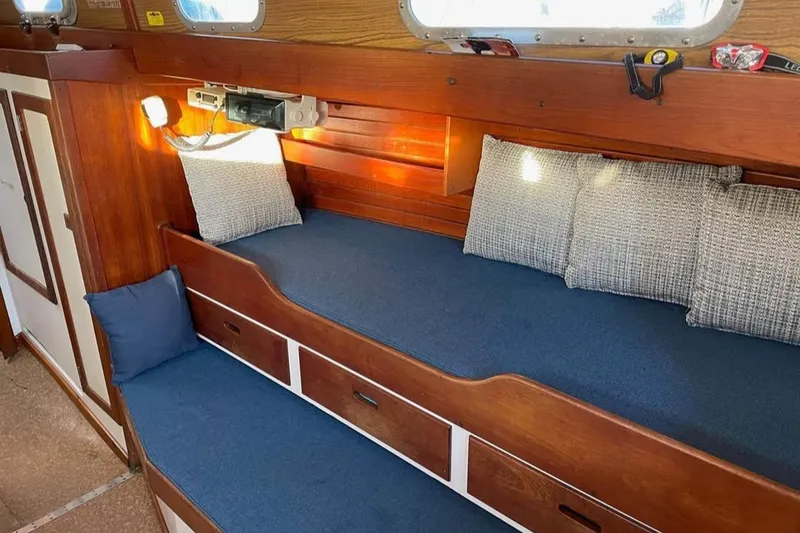 Slide: The Image of Cozy interior of 1969 Tartan 37 sailboat with blue cushions and wooden finish. - 4