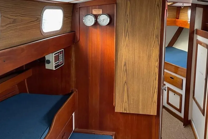 Slide: The Image of Interior of a 1969 Tartan 37 sailboat with wooden paneling and blue cushions. - 6