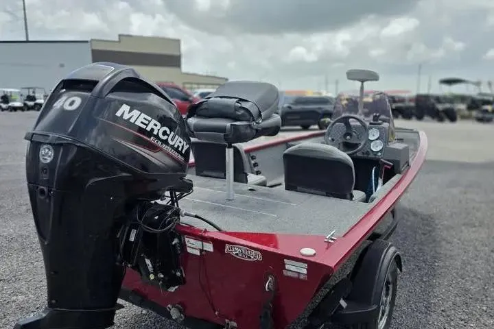 Slide: The Image of 2020 Tracker Pro 160 boat with Mercury engine, red exterior, parked outdoors. - 6