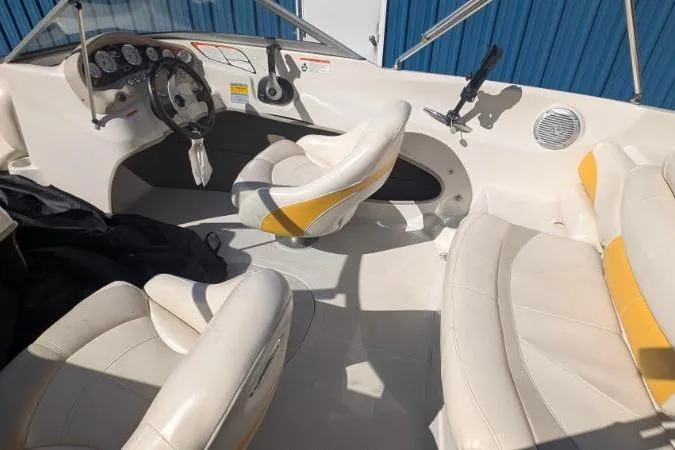 Slide: The Image of 2012 Tahoe Q5L I/O boat interior with white and yellow seating, steering wheel, and dashboard. - 5