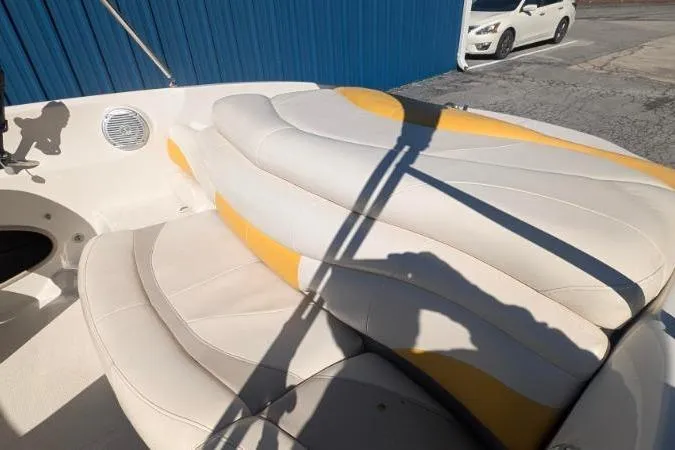 Slide: The Image of 2012 Tahoe Q5L I/O boat interior with white and yellow seating, parked near a blue wall. - 6