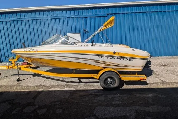 Slide: The Image of 2012 Tahoe Q5L I/O boat in yellow and white, parked on a trailer. - 8