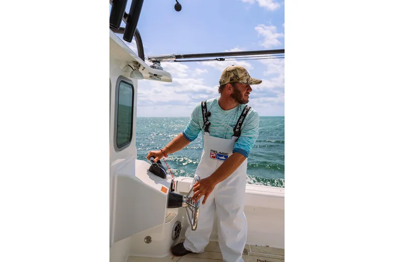 Slide: The Image of Man steering 2026 Parker 247 Explorer boat on open sea under blue sky. - 7