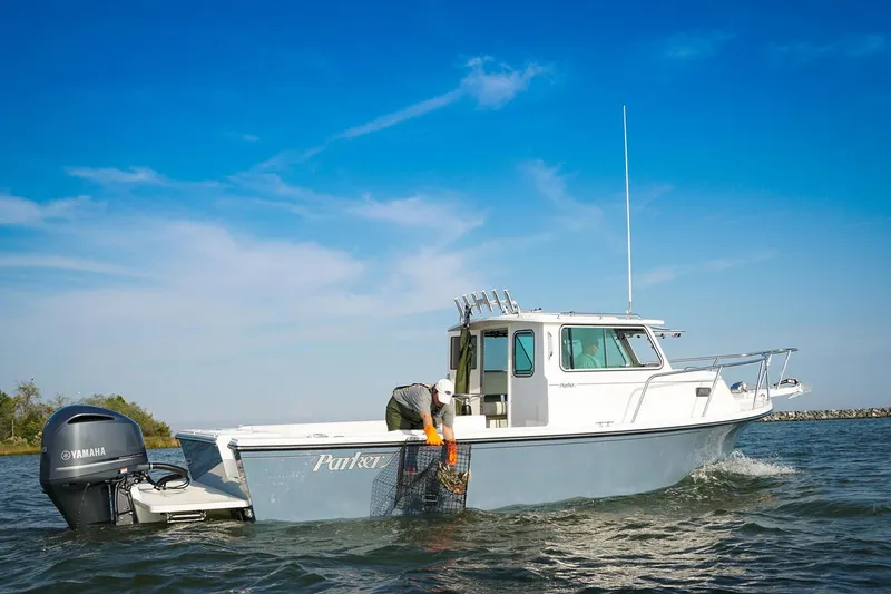 Slide: The Image of Manufacturer Provided Image: 2026 Parker 257 Explorer boat on water, person handling equipment, clear blue sky. - 2