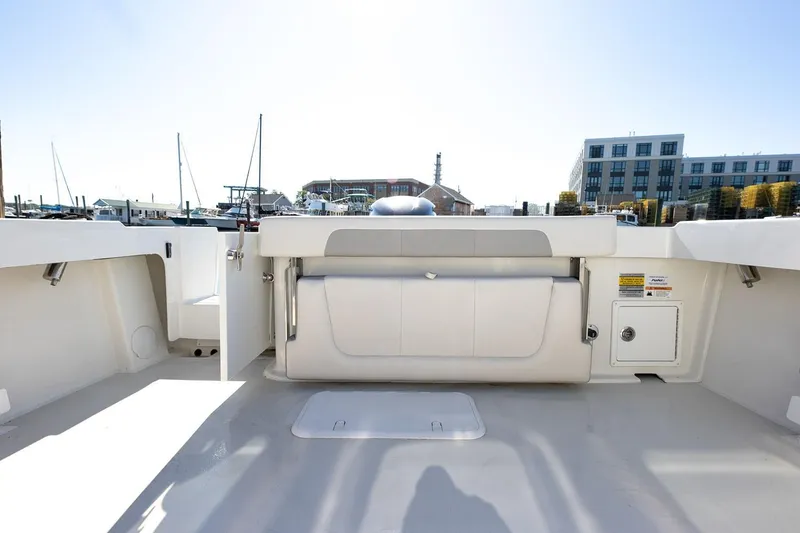 Slide: The Image of Manufacturer Provided Image: 2026 Parker 257 Explorer boat interior with seating and storage, docked at marina. - 7