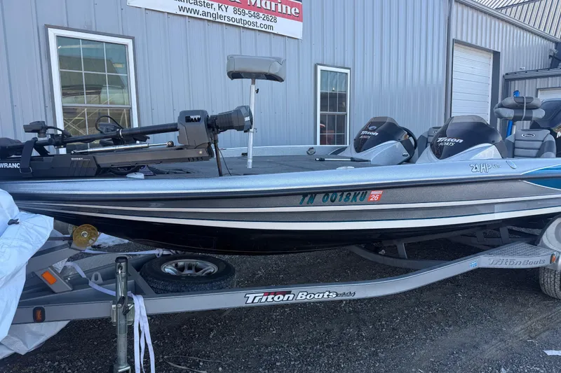 Slide: The Image of 2012 Triton 21HP boat on trailer outside a marine shop. - 3