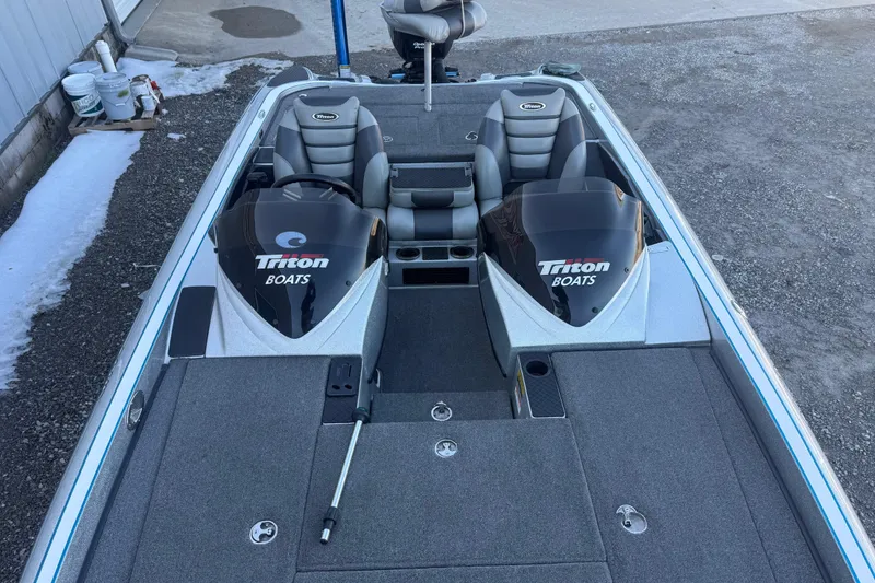 Slide: The Image of 2012 Triton 21HP boat with dual seats and engines, parked on gravel. - 6