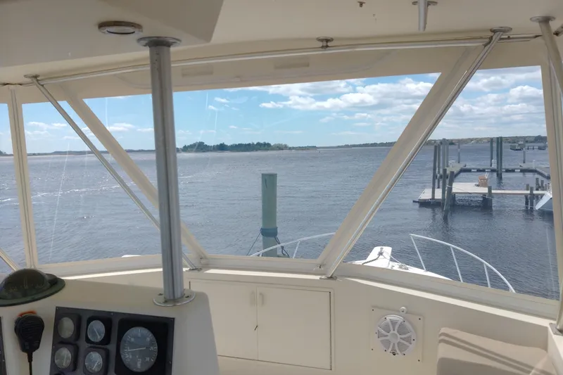 Slide: The Image of View from 1999 Viking 45 Convertible yacht cockpit overlooking calm waters and dock. - 10
