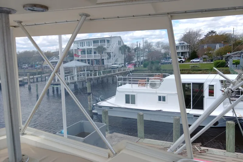 Slide: The Image of 1999 Viking 45 Convertible yacht docked near waterfront homes. - 12