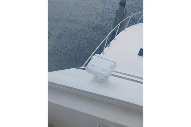 Slide: The Image of 1999 Viking 45 Convertible boat deck with spotlight, docked by water. - 14