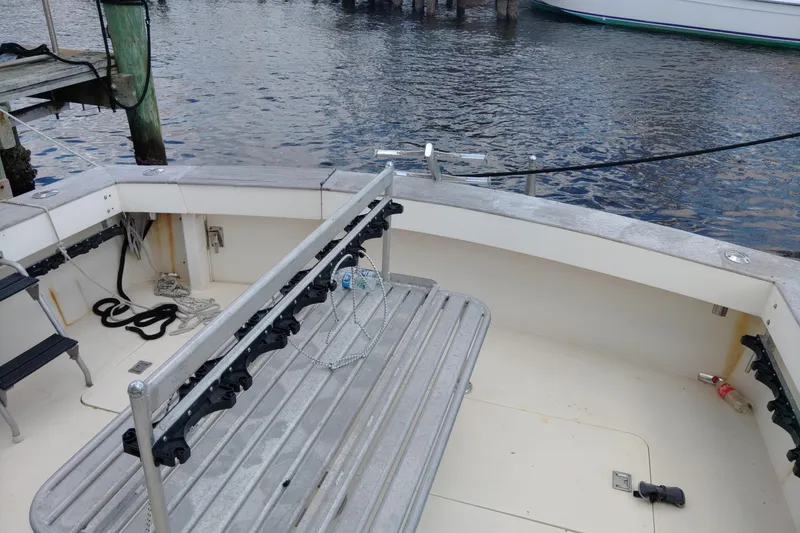 Slide: The Image of 1999 Viking 45 Convertible boat deck with fishing rod holders and dock view. - 18