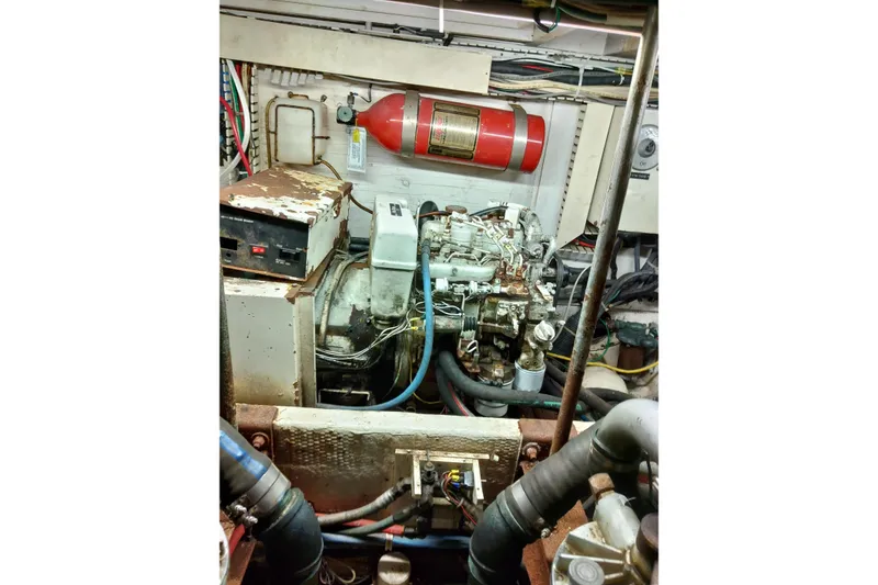Slide: The Image of Engine room of a 1999 Viking 45 Convertible boat with visible machinery and fire extinguisher. - 21