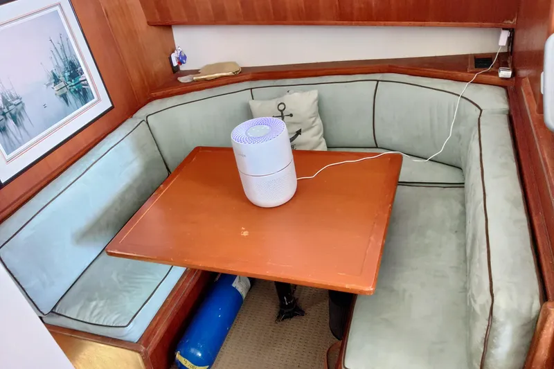 Slide: The Image of Cozy dining area in a 1999 Viking 45 Convertible yacht with a wooden table and cushioned seating. - 24