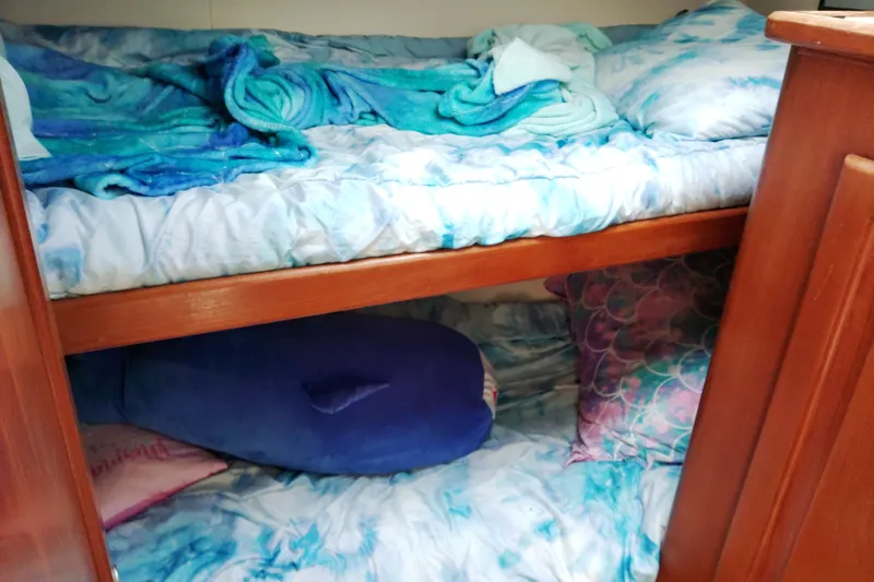 Slide: The Image of Bunk beds with blue bedding in a 1999 Viking 45 Convertible yacht cabin. - 25