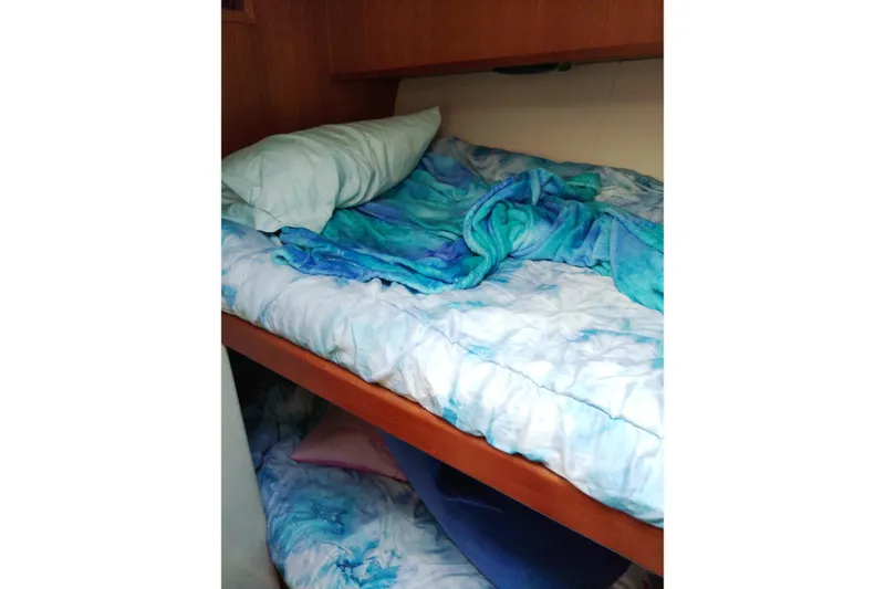 Slide: The Image of Bunk beds with blue bedding inside a 1999 Viking 45 Convertible boat cabin. - 26