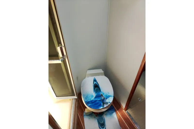 Slide: The Image of Toilet with shark-themed seat cover on 1999 Viking 45 Convertible yacht. - 27