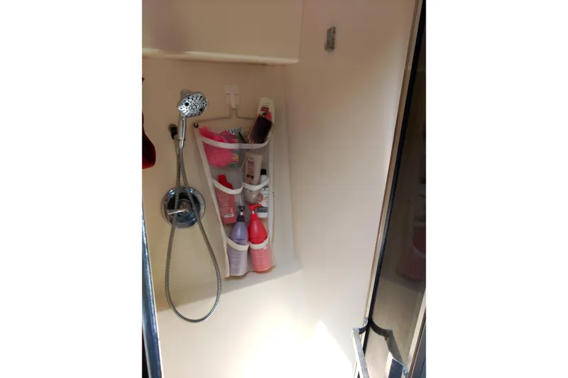 Slide: The Image of Shower area in 1999 Viking 45 Convertible boat with toiletries and handheld showerhead. - 28