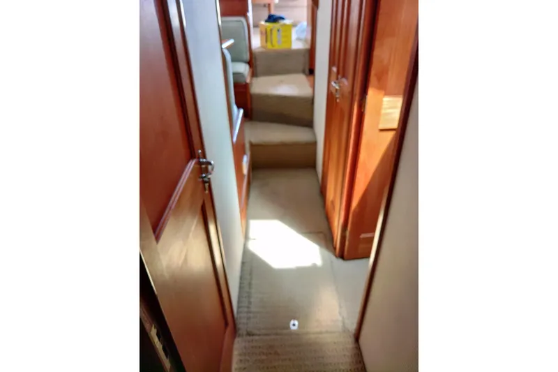 Slide: The Image of Interior hallway of 1999 Viking 45 Convertible yacht with wooden doors and carpeted floor. - 33