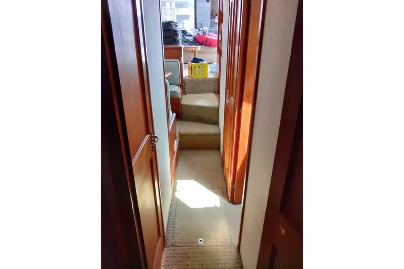 Slide: The Image of Interior hallway of 1999 Viking 45 Convertible yacht with wooden doors and carpeted floor. - 34