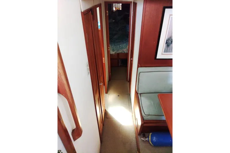 Slide: The Image of Interior hallway of 1999 Viking 45 Convertible yacht with wood paneling and seating area. - 35
