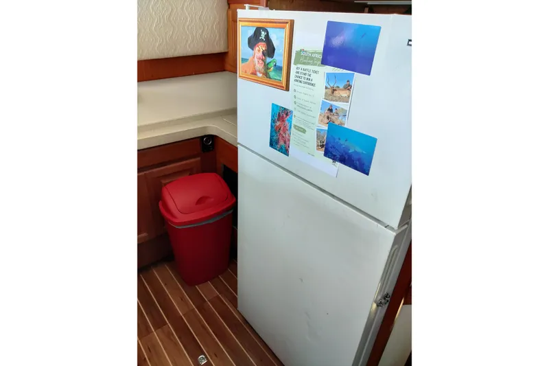 Slide: The Image of Refrigerator in 1999 Viking 45 Convertible boat kitchen with photos and red trash bin. - 36